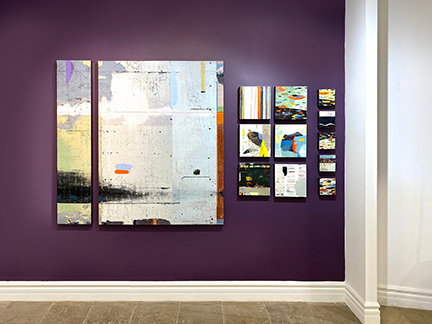 Paintings hung on a purple wall